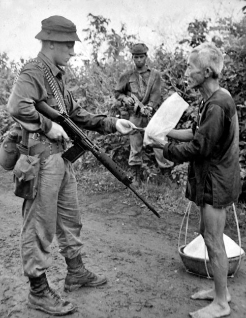 Brian Wilson checks a Vietnamese civilian's identification card, 1967