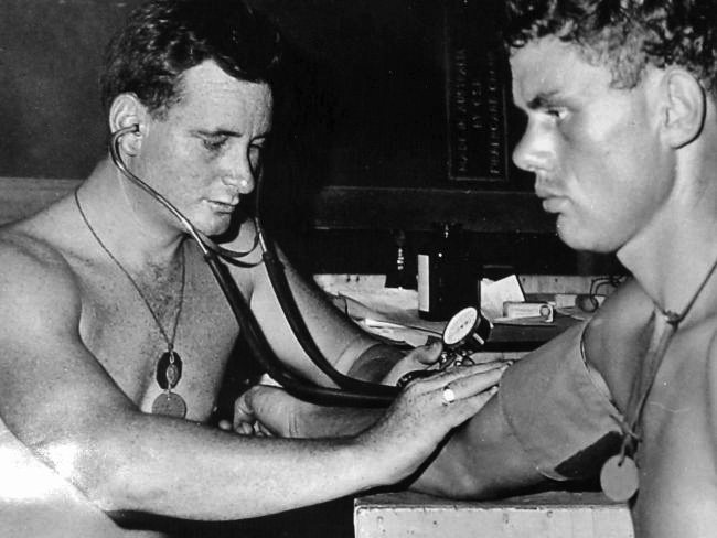 Sgt Joe Tate carries out a routine medical on a New Zealand gunner at Nui Dat, 1966.