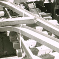 Black and white photograph showing the twisted metal of a damaged bridge.