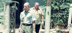 Colour photograph of two men leaving a building