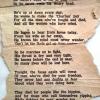 Worn newspaper article with the words of a poem printed on it.